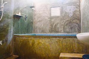 La salle de bains est pourvue d'une douche, d'un lavabo et de toilettes. dans l'établissement Green Leaves Garden - Pinnawala, à Pinnawala