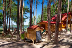 a small wooden house with a playground in the woods at Domek Fiona in Boszkowo