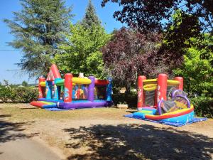 two inflatable playground equipment in a park at Camping Paradis de Maillac in Sainte-Nathalène