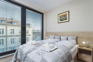 a bedroom with a bed with a large window at Apartments Kraków Rajska 3 by Renters in Krakow