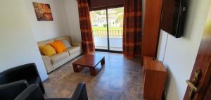 - un salon avec un canapé et une table dans l'établissement Keep Calm Apartments, à Ferragudo