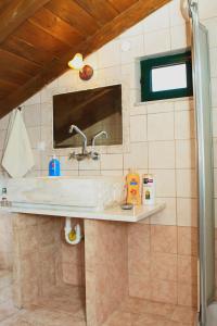 W łazience znajduje się umywalka i lustro. w obiekcie Vgorada w mieście Patsós