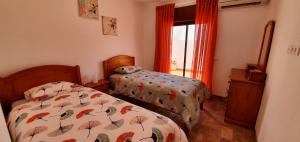 Un dormitorio con dos camas y una ventana en Keep Calm Apartments, en Ferragudo