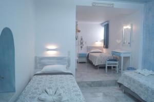ミコノス・シティにあるキマタのベッドルーム1室(ベッド2台付)、バスルーム(シンク付)