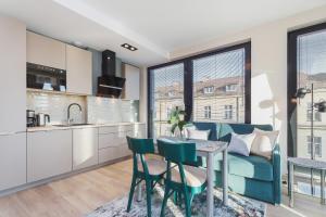 a kitchen and living room with a blue couch and a table at Apartments Kraków Rajska 3 by Renters in Krakow