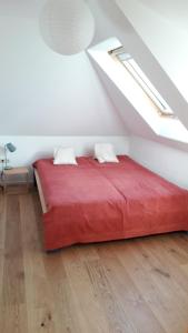 una camera da letto con letto rosso in mansarda di Zentrumsnahe Dachwohnung in grüner Oase a Lauf an der Pegnitz
