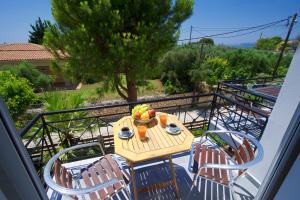 a table and chairs with a bowl of fruit on a balcony at Iris Apartments in Minia