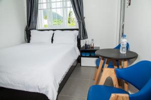 a bedroom with a bed and a table and chairs at THAO LIEN HOTEL in Con Dao