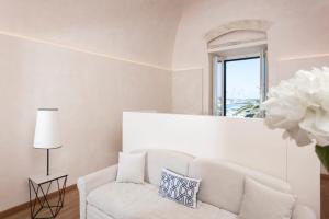 a white living room with a white couch and a window at Dimore Marinare in Trani