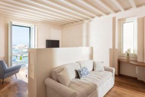 een witte woonkamer met een bank en een stoel bij Dimore Marinare in Trani