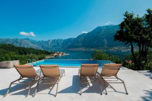 um grupo de cadeiras sentadas ao lado de uma piscina em Villa Casa Nostra - Kotor em Kotor