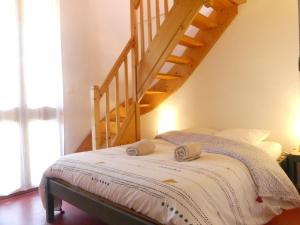 ein Schlafzimmer mit einem Bett und einer Holztreppe in der Unterkunft Gîte de Llo Eco-hébergement de montagne in Llo