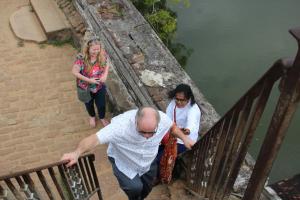 two women and a man walking down the stairs at Miheen Hotel & Resort - Anuradhapura in Mihintale