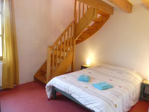 ein Schlafzimmer mit einem Bett und einer Holztreppe in der Unterkunft Gîte de Llo Eco-hébergement de montagne in Llo