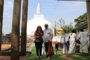 a man and a woman standing in front of a temple at Miheen Hotel & Resort - Anuradhapura in Mihintale