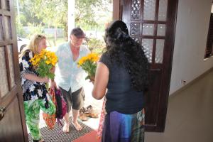 a group of people standing outside a door holding flowers at Miheen Hotel & Resort - Anuradhapura in Mihintale