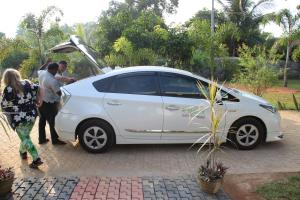 a white car with its hood open with people standing around it at Miheen Hotel & Resort - Anuradhapura in Mihintale