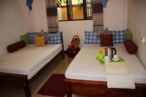 a room with two beds and a table at Miheen Hotel & Resort - Anuradhapura in Mihintale