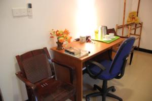 a wooden desk with two chairs and a blue chair at Miheen Hotel & Resort - Anuradhapura in Mihintale