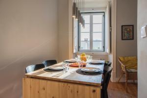 a dining room table with chairs and a large window at Trendy & Lightfull Apartment in Lisbon