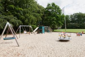 a playground with two swings and a slide at Like home Holiday House 9 A in Varde +14 photos