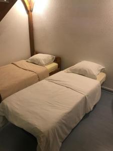 Dos camas en una habitación con sábanas y almohadas blancas. en vue océan à Seignosse, en Seignosse 8 fotos más