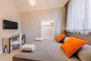 een slaapkamer met een bed met een oranje kussen en een bureau bij Maera B&B Ravello in Ravello