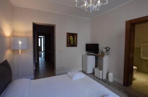 ein Schlafzimmer mit einem weißen Bett und einem Kronleuchter in der Unterkunft Gabri Holiday House in Catania