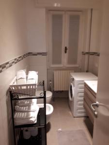 a bathroom with a toilet and a washing machine at Un nido sul lago in Ranzanico