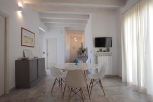 a white dining room with a table and chairs at La Bianca Terrazza in Alessano