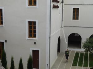 une personne debout à côté d'un bâtiment blanc dans l'établissement Studio au Centre d'Art ARKAD, à Auvillar