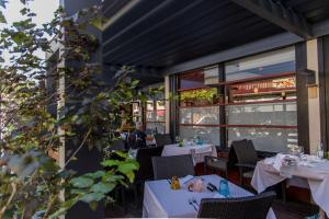 a restaurant with white tables and chairs and a person at Hotel Hvala Superior - Topli Val in Kobarid