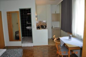 kuchnia i jadalnia ze stołem oraz łazienka w obiekcie Appartmenthaus Josefikeller w mieście Podersdorf am See