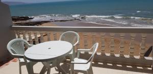 a table and chairs on a balcony with the ocean at Surfapartment Taghazout Nr 6 in Taghazout +13 photos