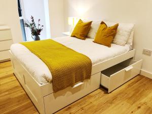 a large white bed with yellow pillows in a bedroom at Ekhaya three in Manchester