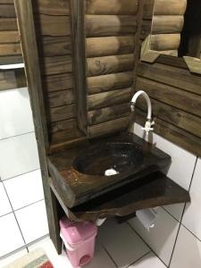 um lavatório de madeira com uma torneira na casa de banho em Cabanas MFK em Machadinho
