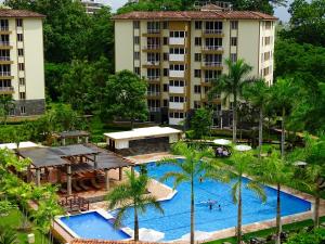 an aerial view of a resort swimming pool with palm trees at 3Rooms Amaizing Beach Studio in Jacó