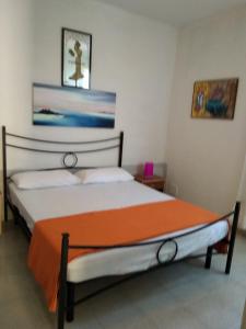 ラ・カレッタにあるAppartamento-La Calettaのベッドルーム1室(オレンジの毛布付きのベッド1台付)