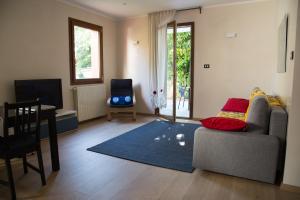 sala de estar con sofá y alfombra azul en Appartamento con giardino Le Querce, en Sistiana
