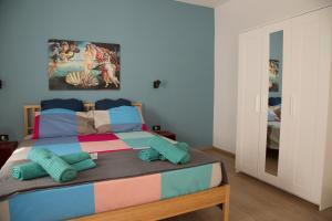 una camera da letto con un letto con coperte e cuscini colorati di Appartamento con giardino Le Querce a Sistiana