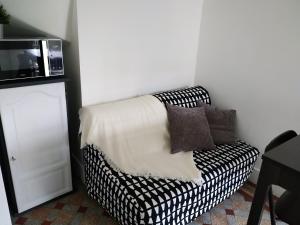 a black and white couch in a room with a microwave at imperatrice 2 in Berck-sur-Mer