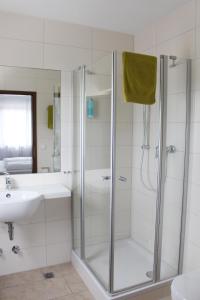 a white bathroom with a shower and a sink at Landgasthof Ritter in Orsingen-Nenzingen