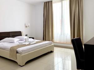 a bedroom with a bed and a large window at Pensiunea OK in Vişeu de Sus +46 photos