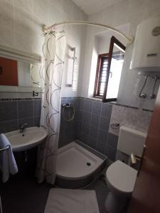 bagno con lavandino, servizi igienici e specchio di Apartments NIKA a Vodice
