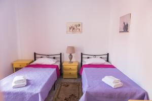 two beds in a room with a blue wall at Sea View in Loutraki