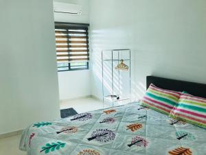 Family homestay في كوالا سيلانجور: غرفة نوم مع سرير ولحاف ملونة ونافذة