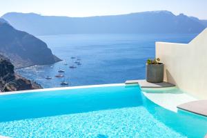 a swimming pool with a view of the ocean at Aloia Villas in Oia