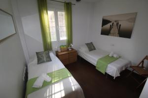 ベナアビスにあるBenahavis Penthouse Apartmentの緑のカーテンがかかった部屋にベッドが2つ +19枚の写真