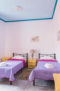 a bedroom with two beds and two lamps at Sea View in Loutraki