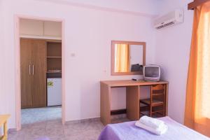 a bedroom with a bed, desk and a television at Sea View in Loutraki